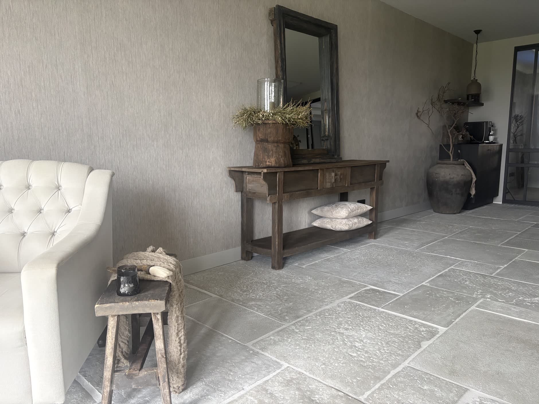 Interieur met afgewerkte wanden, een houten wandtafel en een grote zwarte spiegel